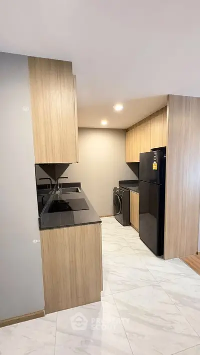 Modern kitchen with sleek wooden cabinets and black appliances