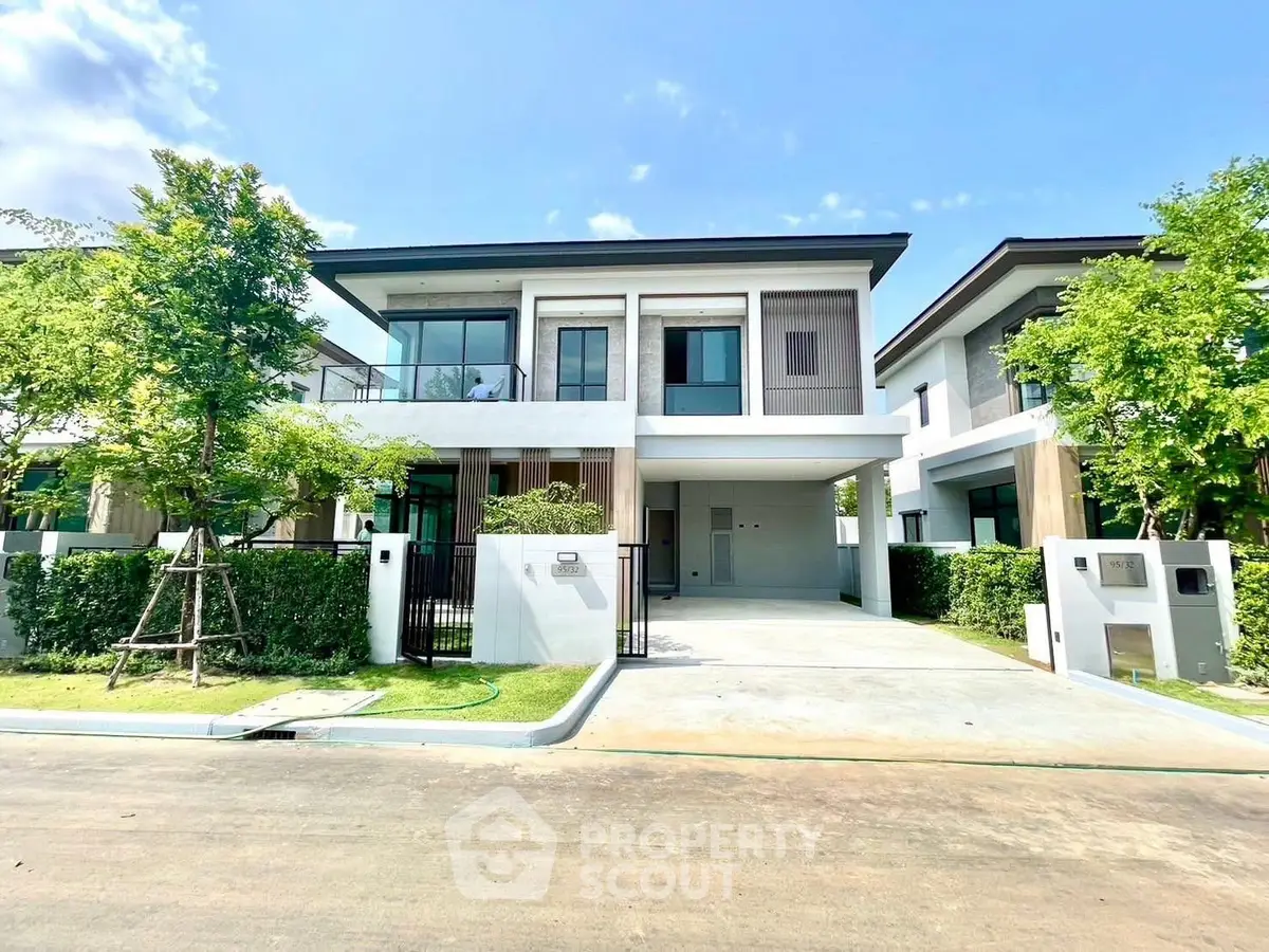 Modern two-story house with sleek design and spacious driveway in a serene neighborhood.