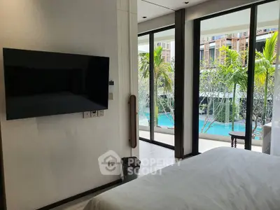 Luxurious bedroom with pool view and modern amenities in a tropical setting.