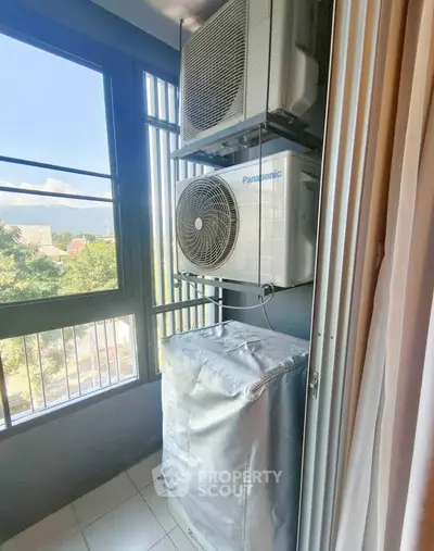 Compact balcony with air conditioning units and protective cover, offering a practical outdoor space.