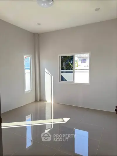 Bright empty room with large windows and glossy tiled floor