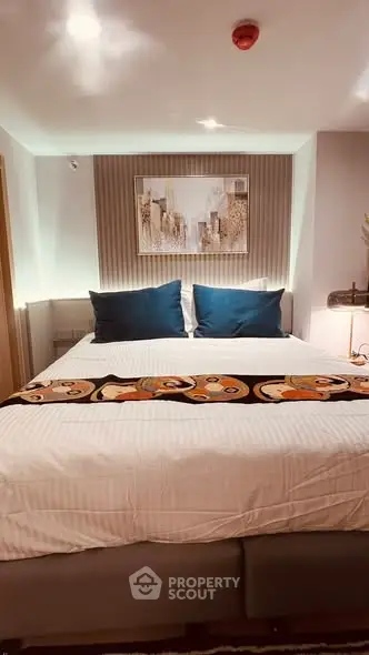 Luxurious bedroom with stylish decor and plush bedding in modern apartment.