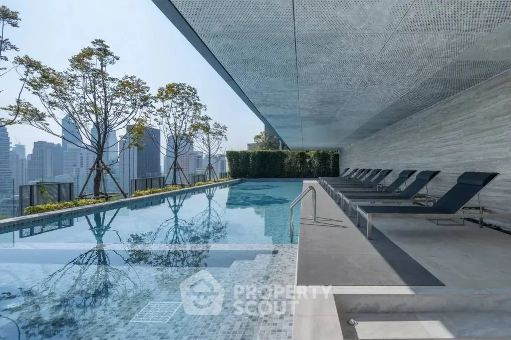 Luxurious rooftop pool with city skyline view and modern lounge chairs.