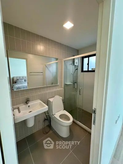 Modern bathroom with sleek design, featuring a glass shower enclosure and stylish fixtures.