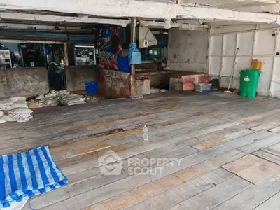 Spacious open area with wooden flooring, ideal for creative renovation or storage space.