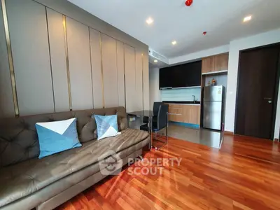 Modern living room with stylish decor and open kitchen layout, featuring hardwood floors and contemporary furniture.
