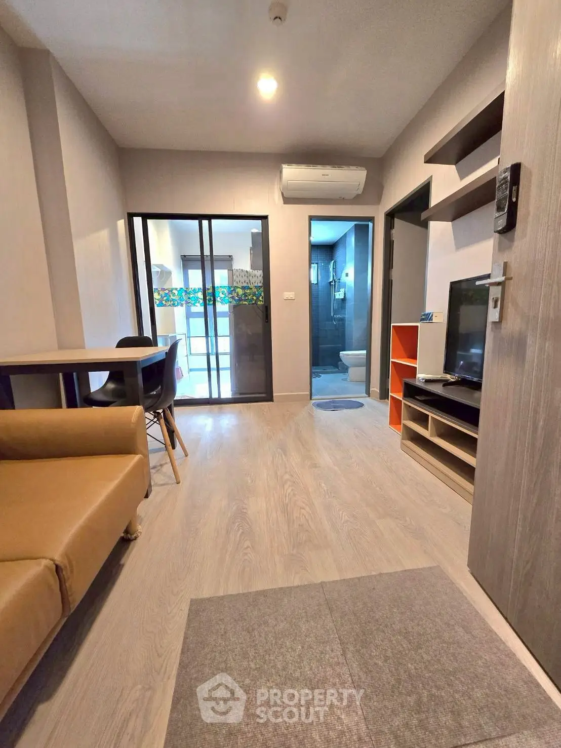 Modern living room with cozy seating and sleek TV setup in stylish apartment