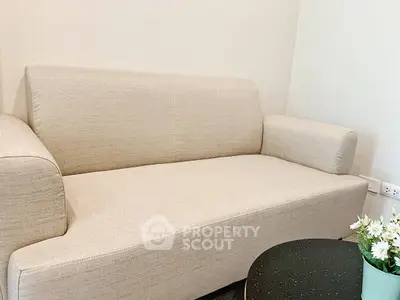 Cozy beige sofa in a modern living room setting with a stylish coffee table and decorative plant.