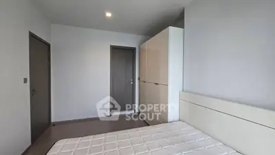 Modern minimalist bedroom with sleek wardrobe and comfortable bed in a bright apartment.