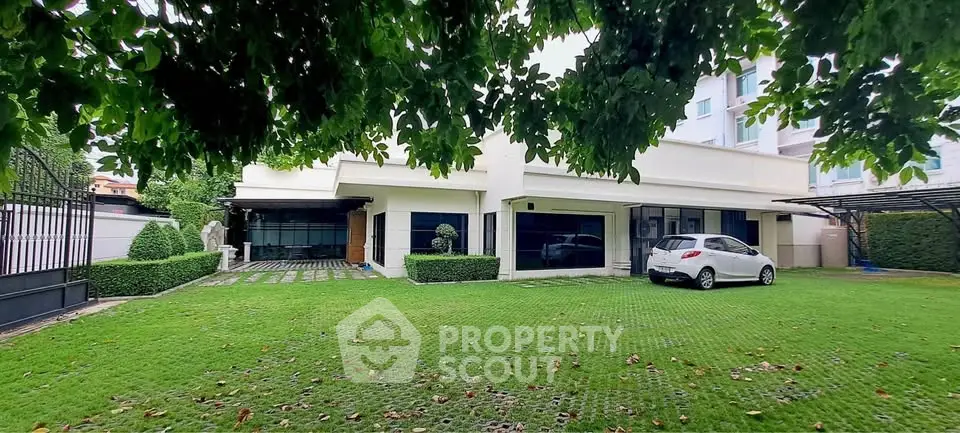 Spacious modern home with lush green lawn and carport, perfect for family living.