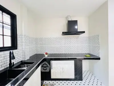 Modern kitchen with sleek black countertops and white subway tile backsplash
