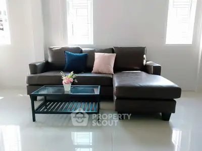 Modern living room with sleek leather sofa and glass coffee table, perfect for stylish comfort.