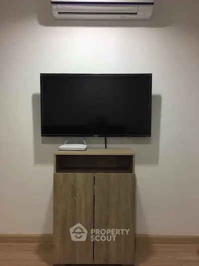 Modern living room with wall-mounted TV and sleek wooden cabinet