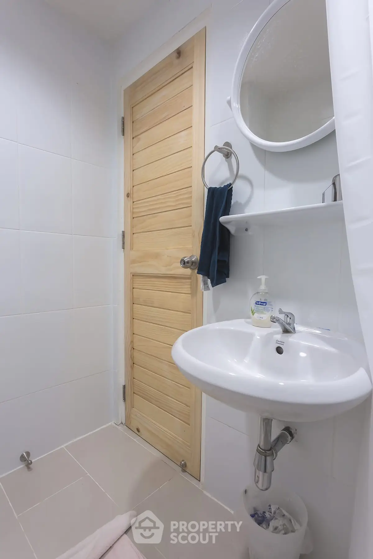 Modern bathroom with wooden door and sleek white fixtures