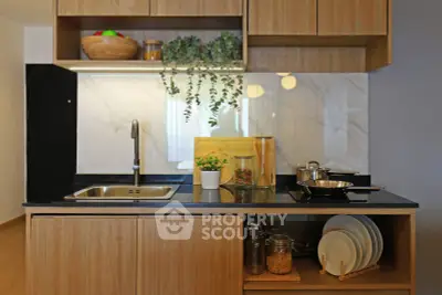 Modern kitchen with sleek wooden cabinets, black countertop, and stylish decor in a contemporary apartment.