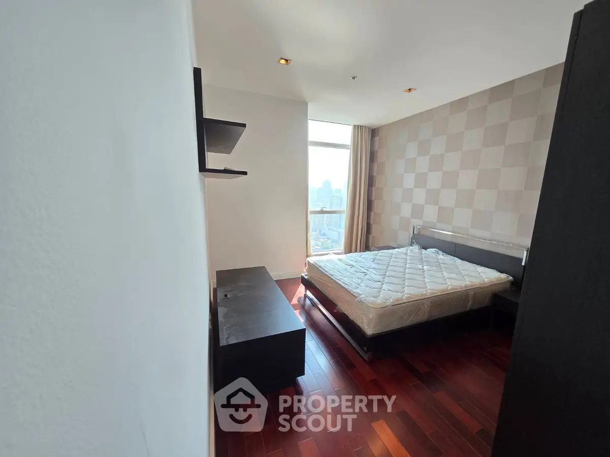 Spacious bedroom with city view and modern decor in luxury apartment
