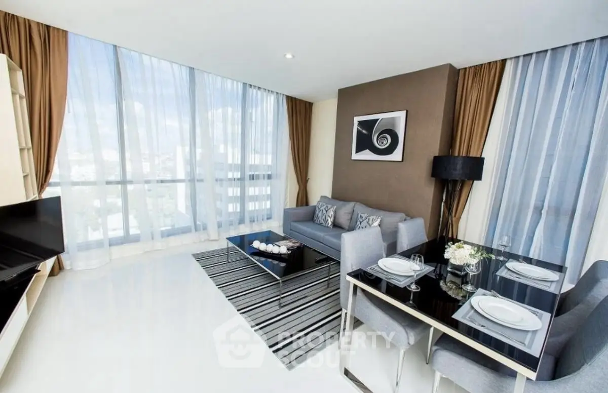 Modern living room with dining area and large windows offering city views.