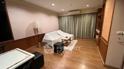 Spacious living room with elegant wooden flooring and cozy seating area, perfect for relaxation and entertainment.