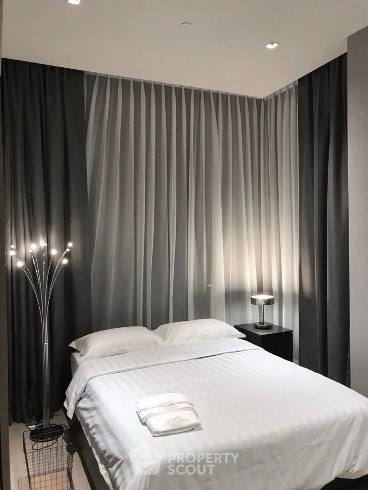Modern bedroom with elegant lighting and stylish curtains, perfect for a cozy retreat.