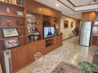 Spacious living room with wooden cabinetry and marble flooring