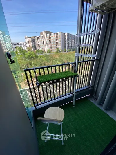 Charming balcony with artificial grass and city view, perfect for relaxation.