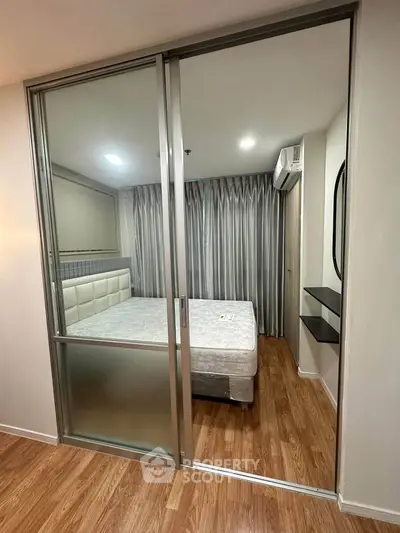 Modern bedroom with sliding glass doors and wooden flooring