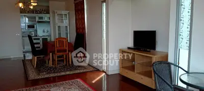 Spacious living room with dining area and natural light, featuring modern furniture and open layout.
