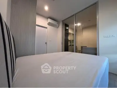Modern bedroom with mirrored closet and air conditioning in stylish apartment.