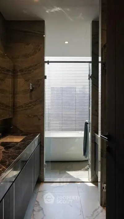 Luxurious bathroom with marble finishes and a sleek bathtub, perfect for relaxation.