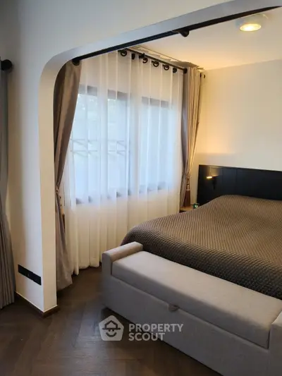 Elegant bedroom with cozy bed, stylish curtains, and modern lighting in a serene setting.