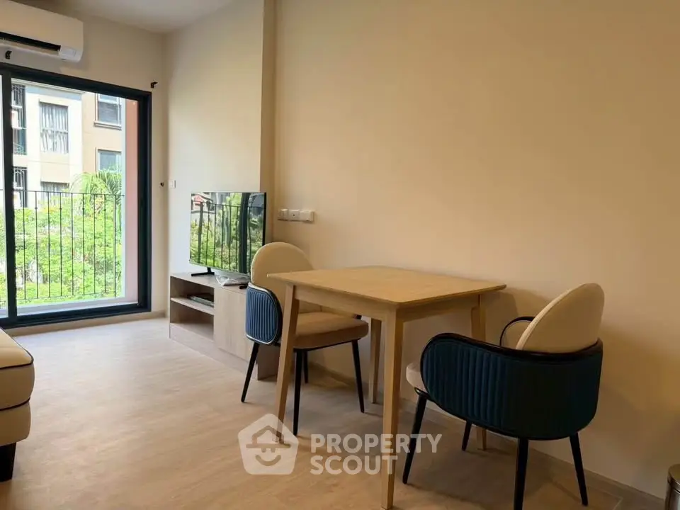 Modern living room with stylish furniture and large window offering natural light and garden view.