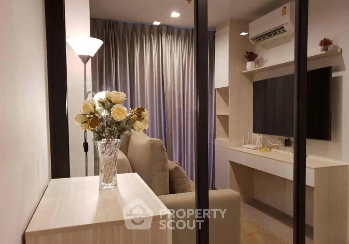 Modern living room with elegant decor and air conditioning, featuring a cozy sofa and stylish lighting.
