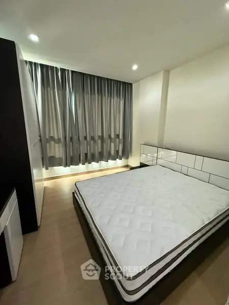 Modern bedroom with large window and stylish decor in a contemporary apartment.