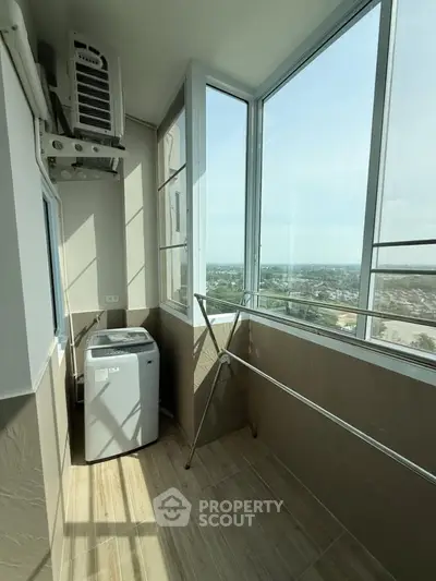 Bright balcony with washing machine and stunning city view, perfect for laundry and relaxation.