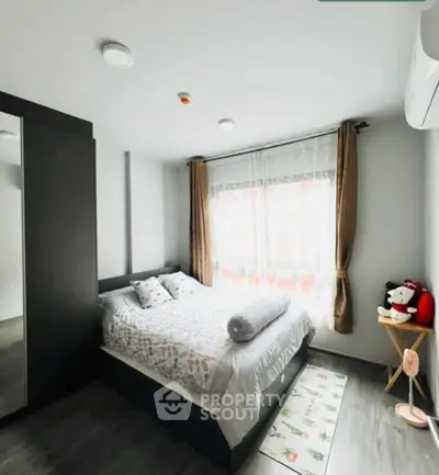 Cozy bedroom with modern decor and large window for natural light
