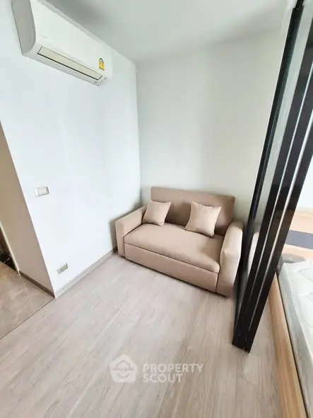 Cozy small living room with beige sofa and air conditioning