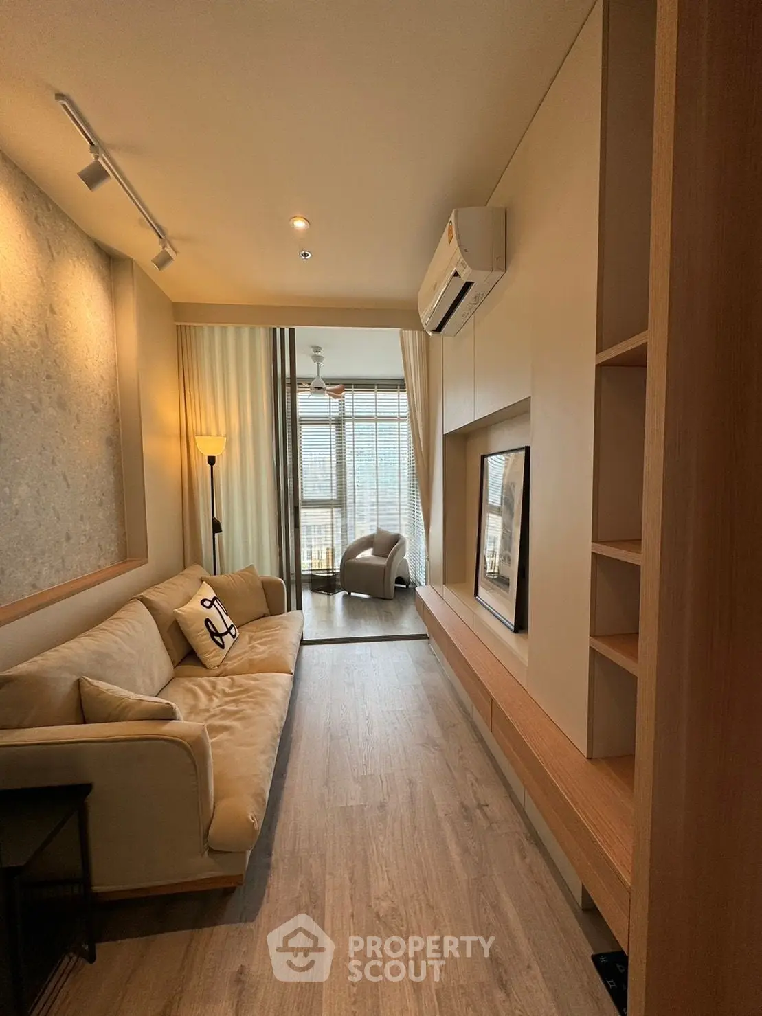 Stylish living room with modern decor and natural light, featuring a cozy sofa and elegant wooden flooring.