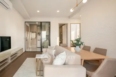 Modern living room with elegant decor and open layout, featuring a cozy dining area and stylish furniture.