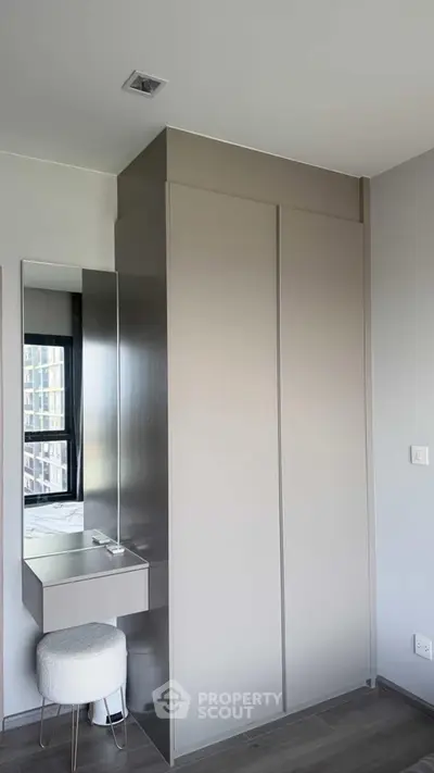 Modern bedroom with sleek wardrobe and vanity in a stylish apartment