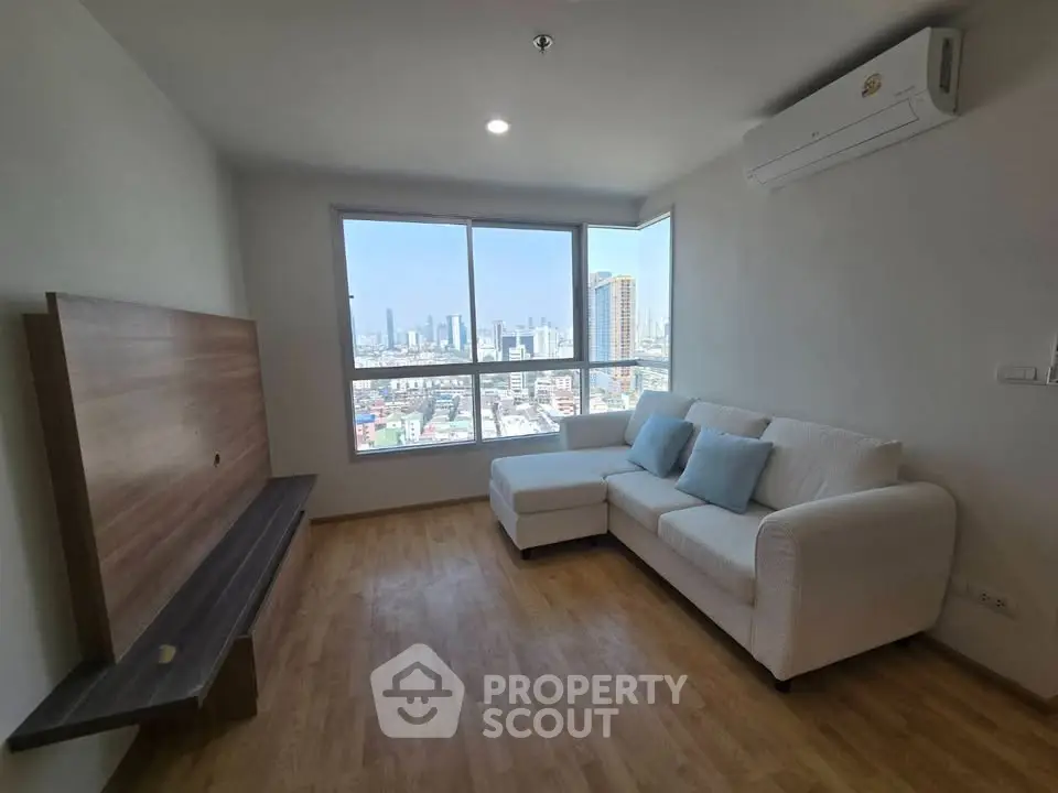 Modern living room with city view, featuring a cozy white sofa and sleek wooden flooring.