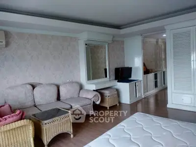 Spacious bedroom with elegant decor and cozy seating area in a stylish apartment.