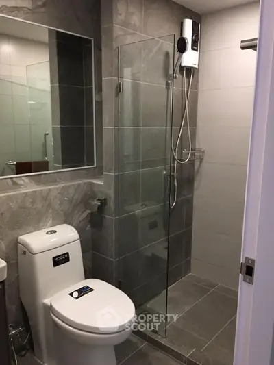 Modern bathroom with sleek shower and toilet in contemporary apartment.