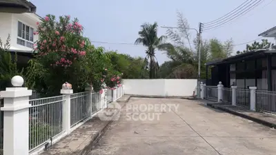 Charming residential driveway with lush greenery and modern fencing