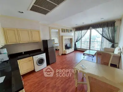 Spacious open-layout living room with kitchen, featuring large windows and elegant furnishings.
