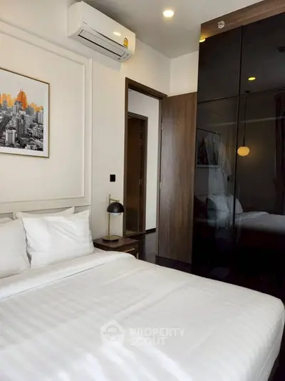 Modern bedroom with sleek design and air conditioning in a stylish apartment.