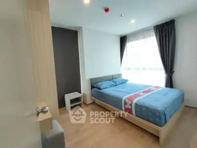 Modern bedroom with large window and stylish decor in a cozy apartment.