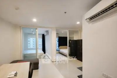 Modern apartment interior with two bedrooms and sleek furnishings, featuring large windows for natural light.