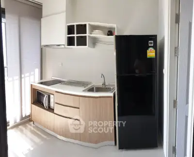 Modern compact kitchen with sleek black fridge and built-in microwave