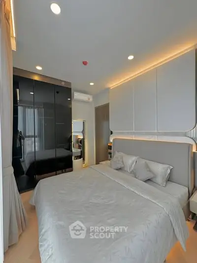 Modern bedroom with sleek design, featuring a comfortable bed and stylish lighting, perfect for relaxation.