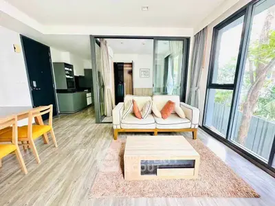 Modern living room with large windows and stylish furniture in a bright apartment.